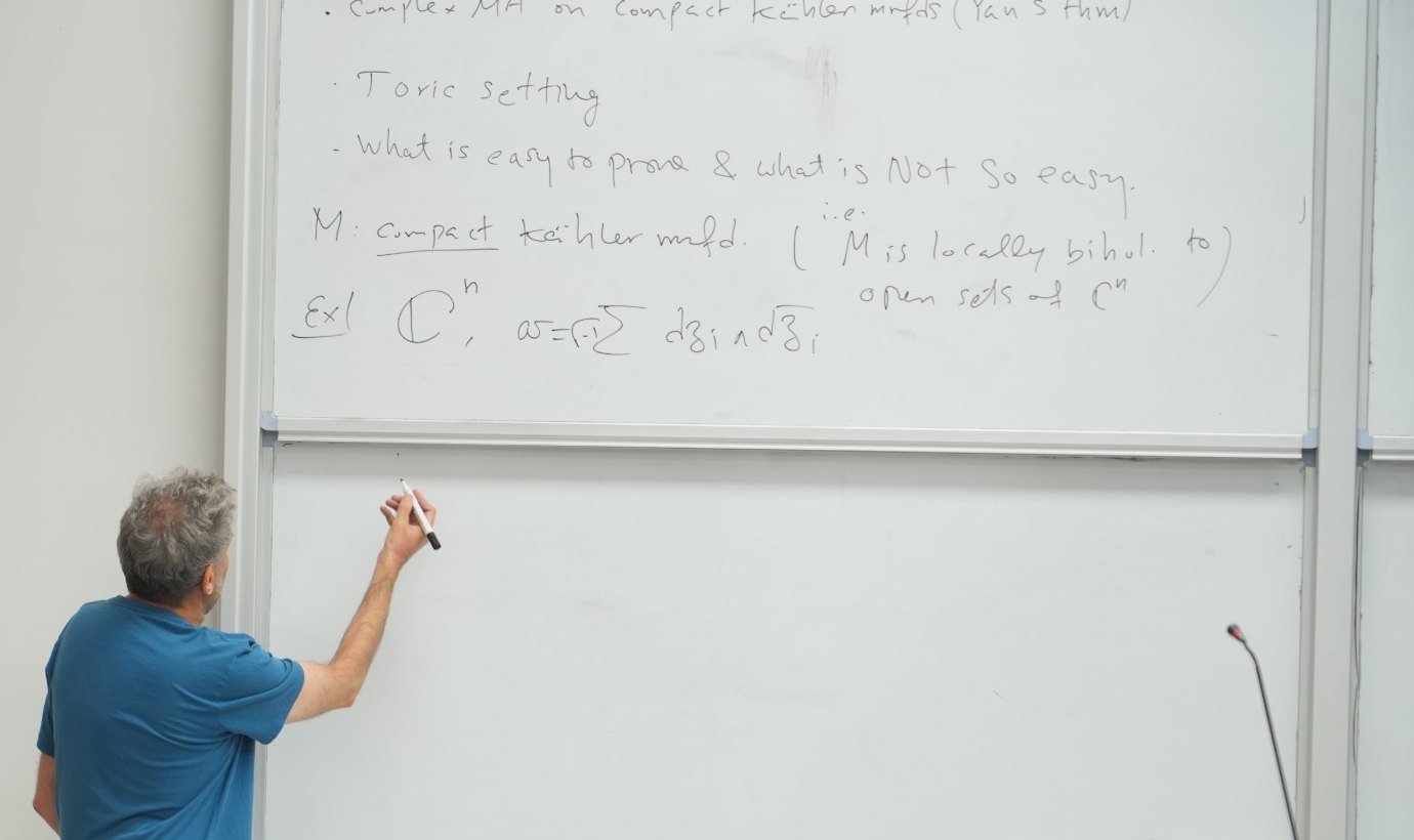 A lecture on complex Monge–Ampère equations on compact Kähler manifolds, with the statement written on the board